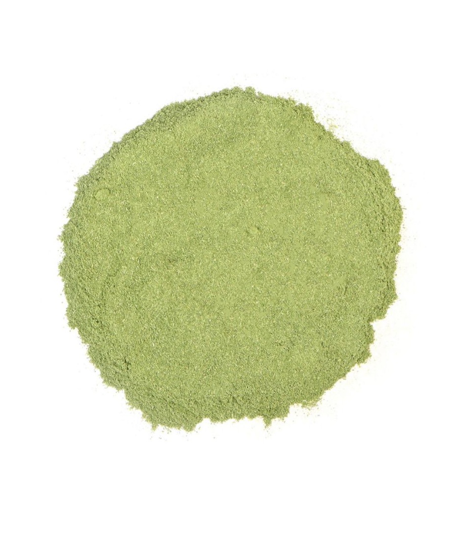Bright green alfalfa leaf powder on a white background, representing natural detoxification and nutrient-rich superfood benefits.