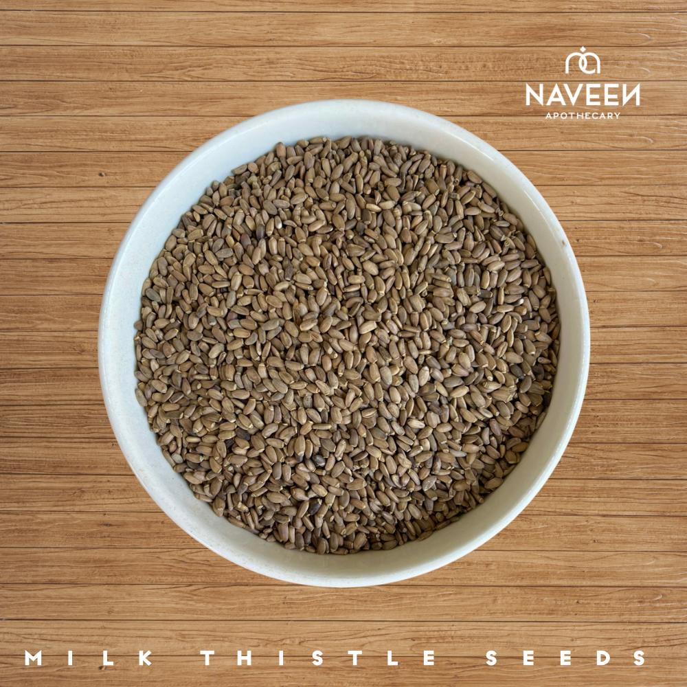 A bowl of milk thistle seeds on a wooden surface with the Naveen Apothecary logo.