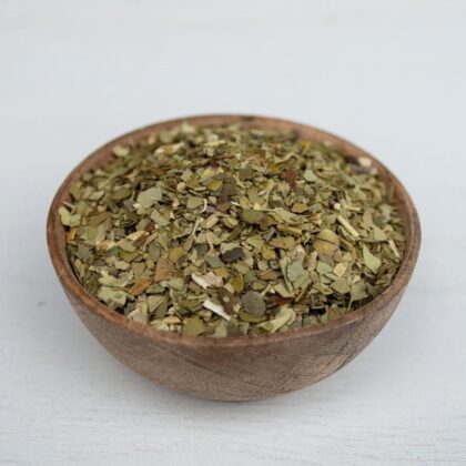 A brown bowl containing yerba mate tea leaves from Naveen Herbs on a white background