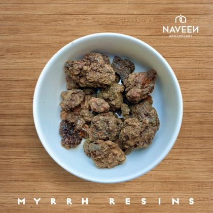 A bowl of myrrh resin chunks on a wooden surface with the Naveen Apothecary logo.