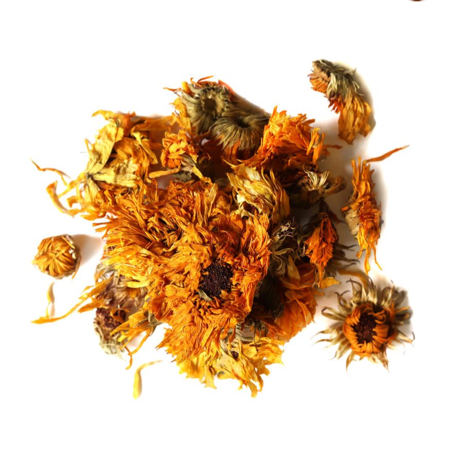 Pile of dried calendula flowers from Naveen Herbs on a white background