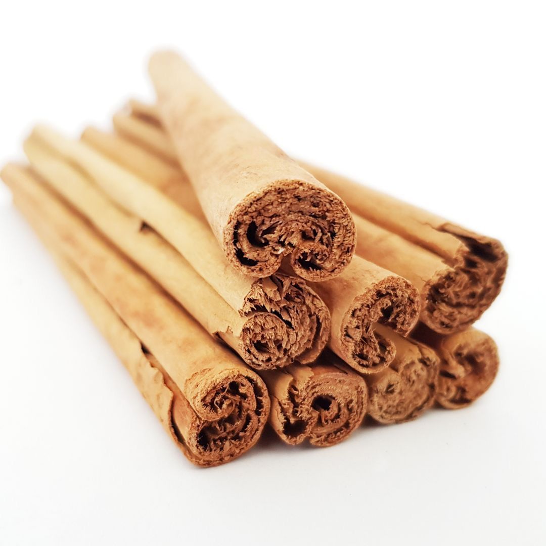 Pile of Ceylon cinnamon sticks from Naveen Herbs on a white background
