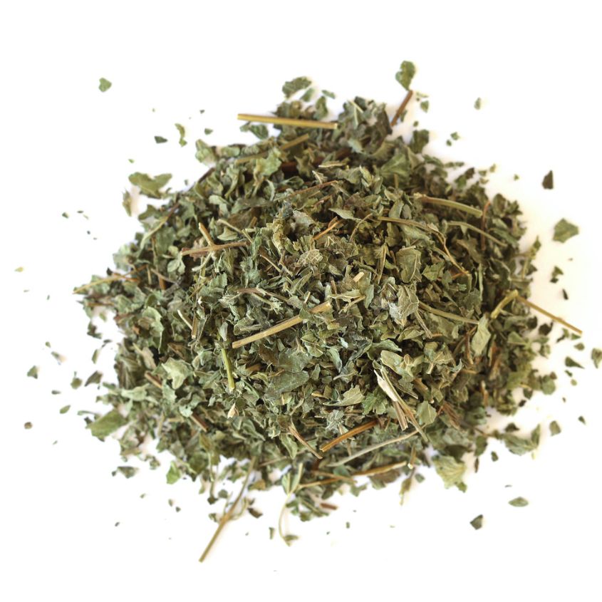 Pile of dried lemon balm leaves on a white background