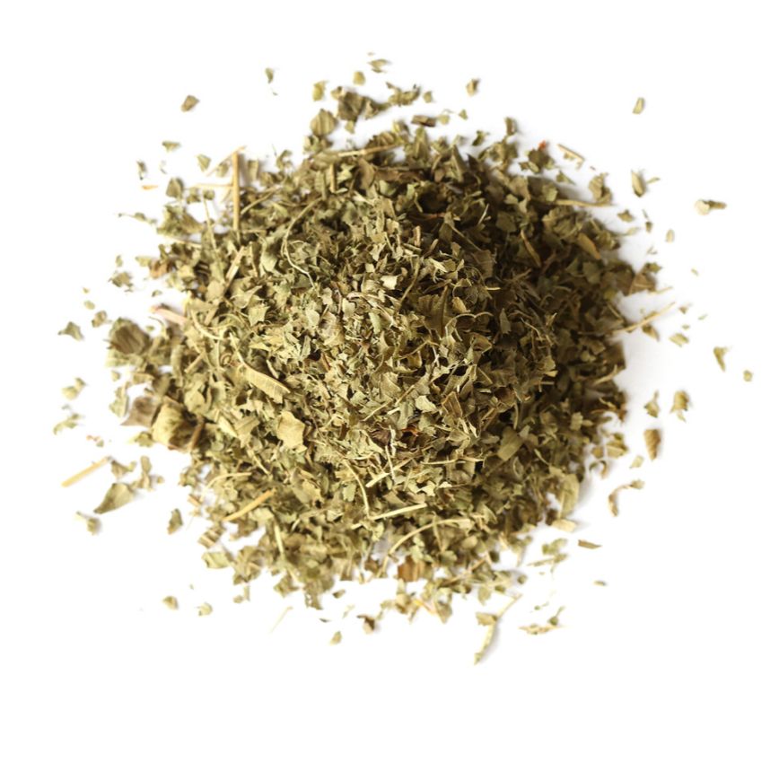 Pile of dried lemon verbena leaves on a white background