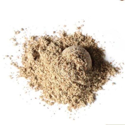 Pile of milk thistle seed powder on a white background