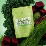 Super greens powder pouch with kale leaves, wheatgrass, and beetroot cubes showing organic detox superfood blend